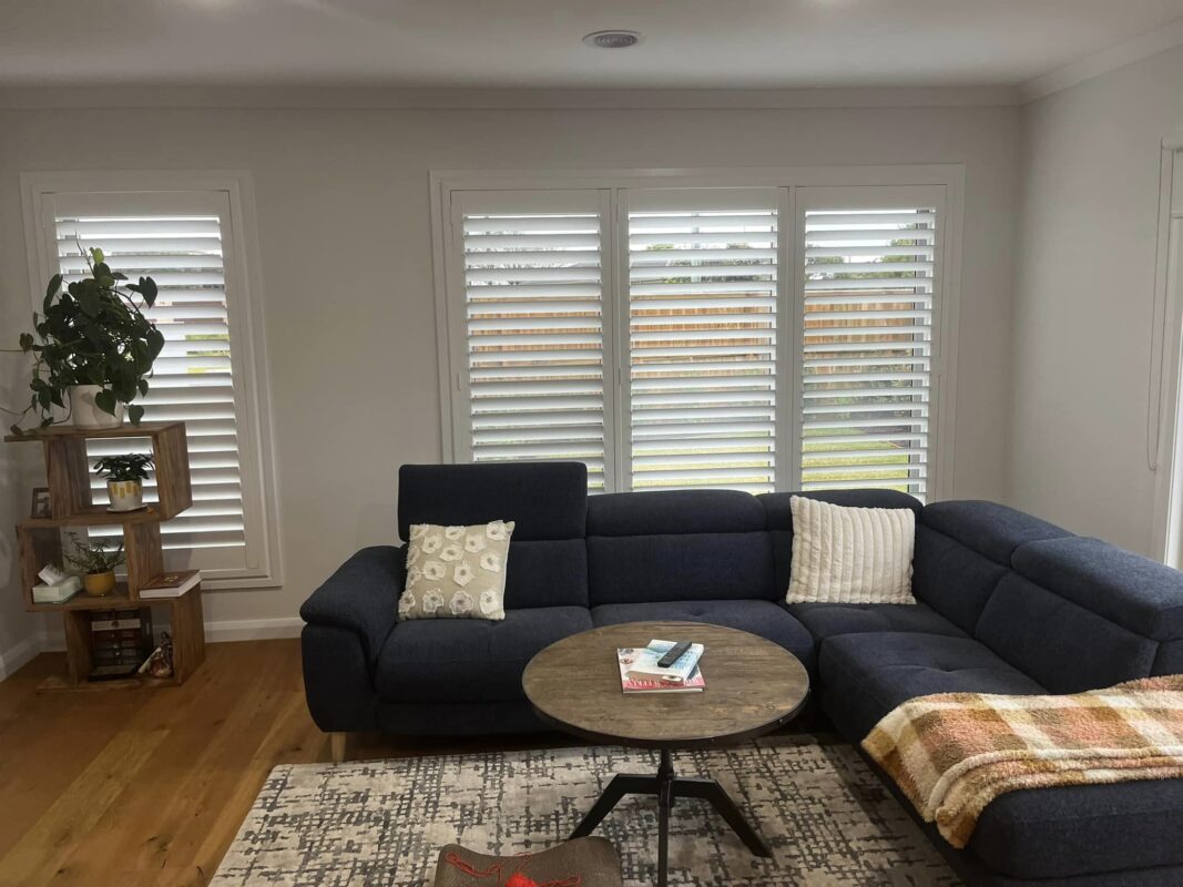 White plantation shutters with the louvres tilted open in a living room