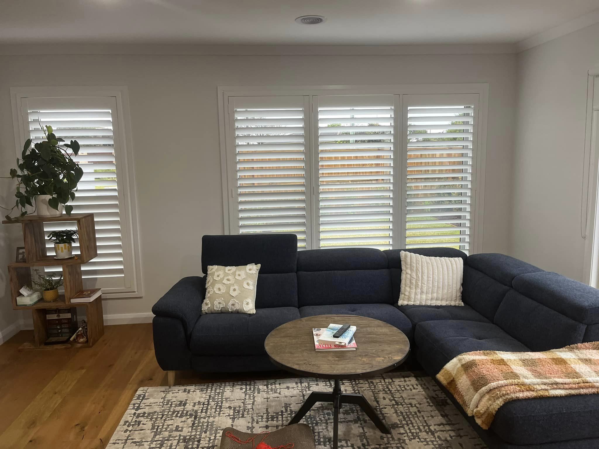 White plantation shutters with the louvres tilted open in a living room