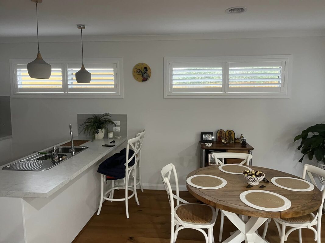 White plantation shutters on high kitchen and dining room windows