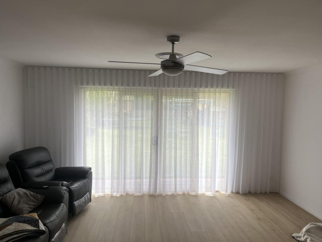 White S-Fold sheer curtains filtering daylight across sliding doors in a family living room
