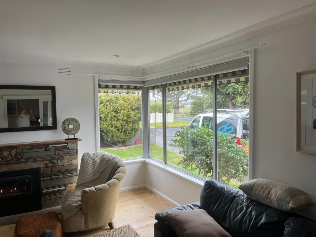 Roller blinds partly raised on a corner window in a lounge room